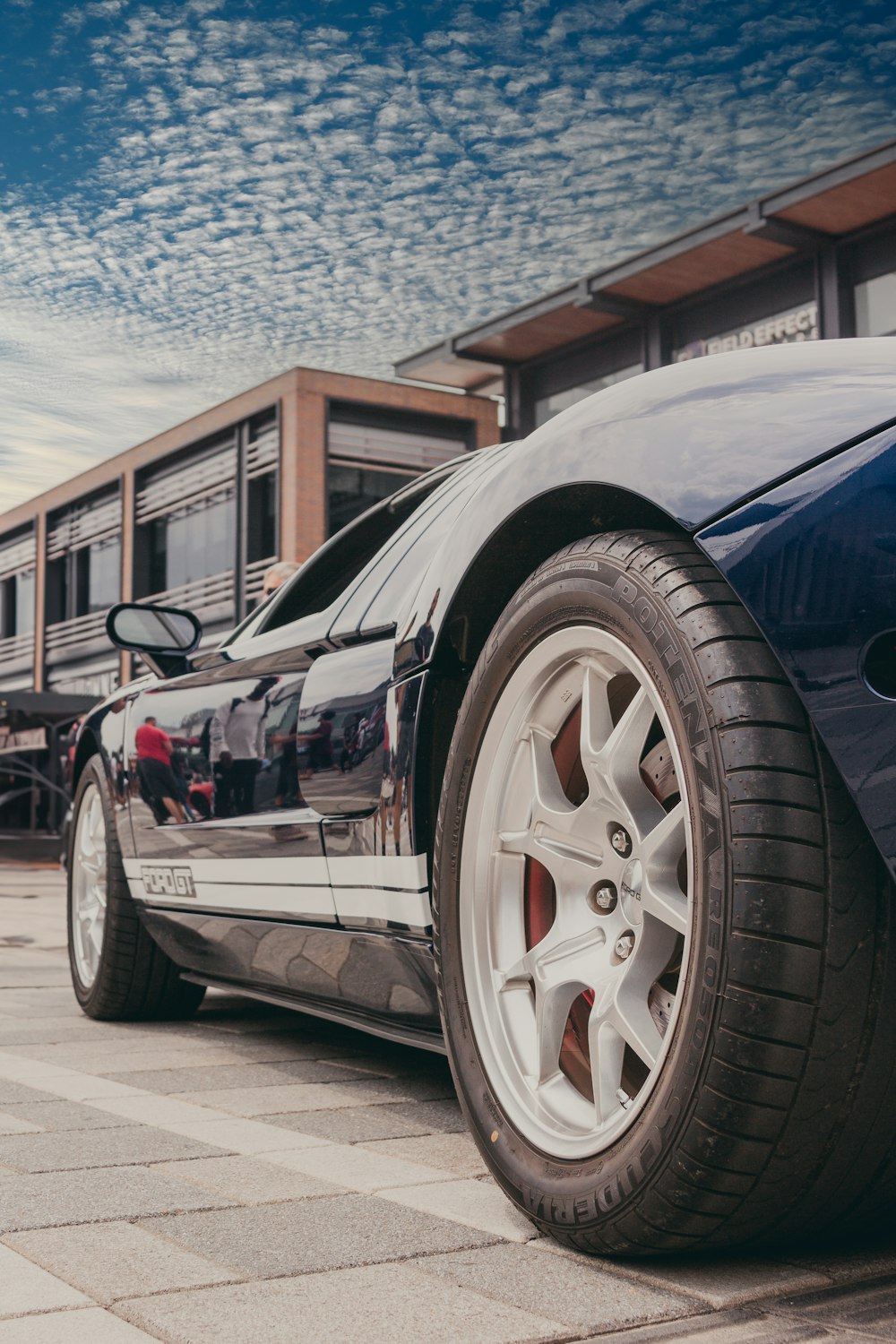 a blue sports car parked in front of a building