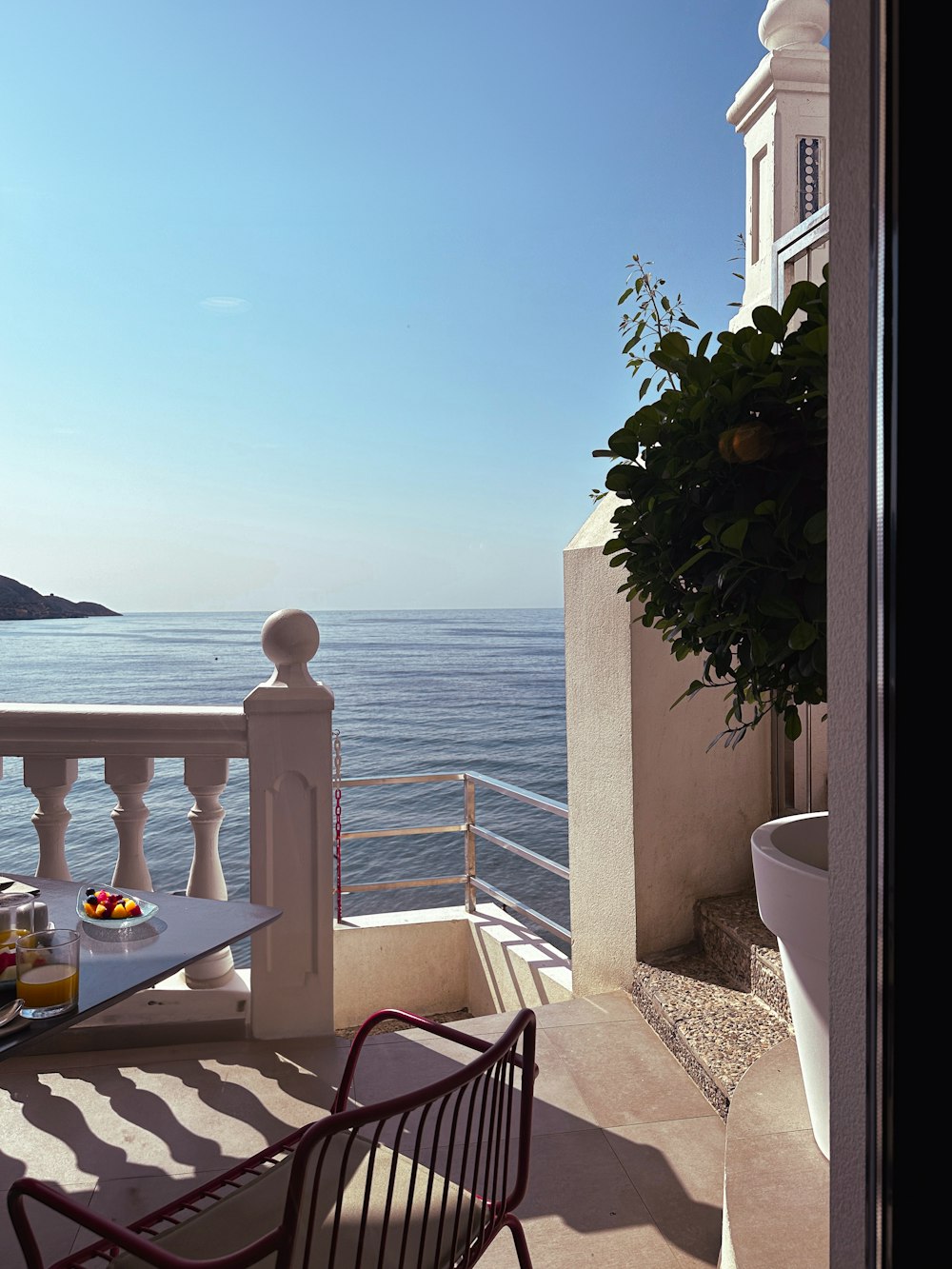 a balcony with a table and chairs overlooking the ocean