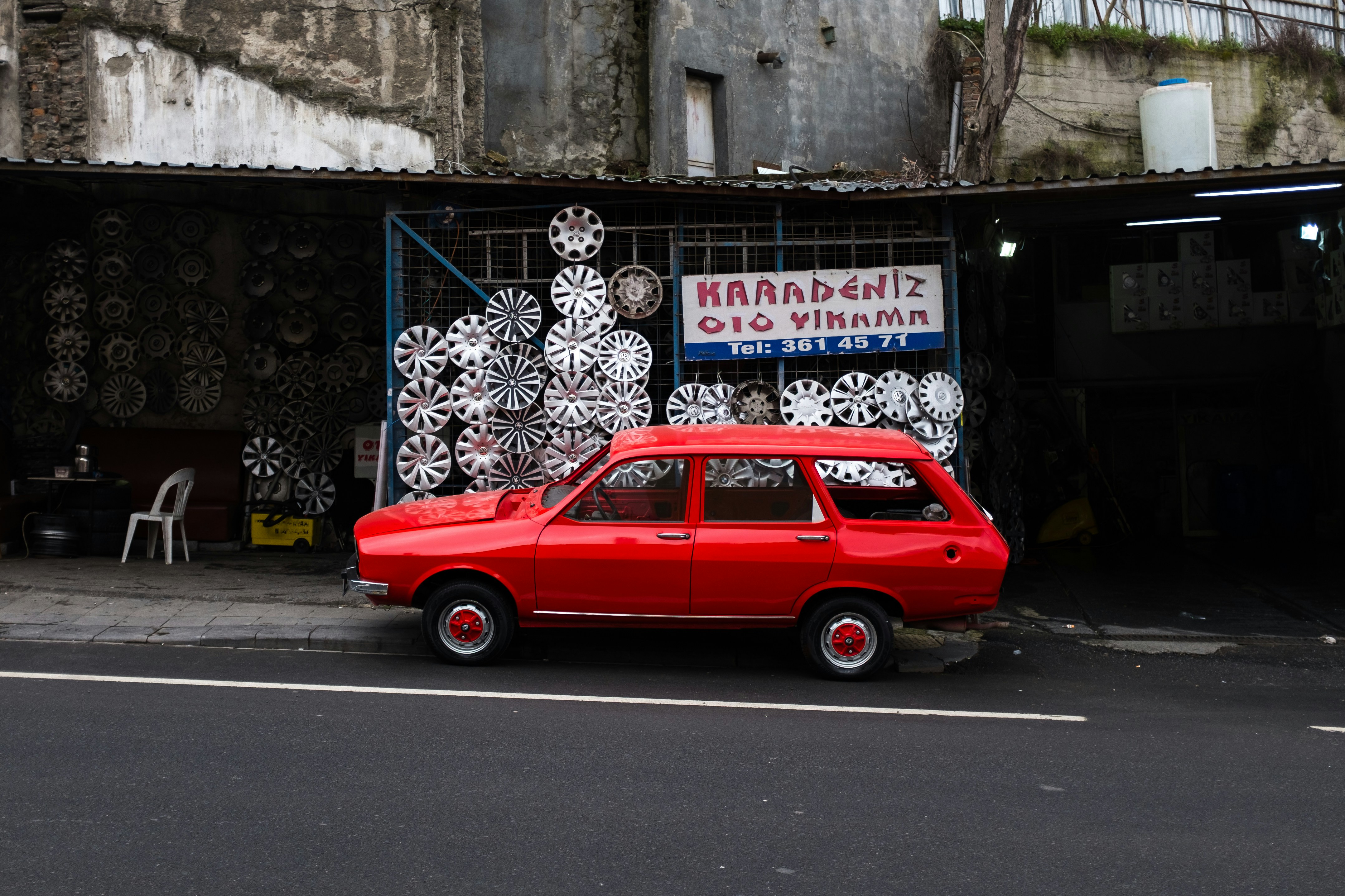 a red car parked in front of a building