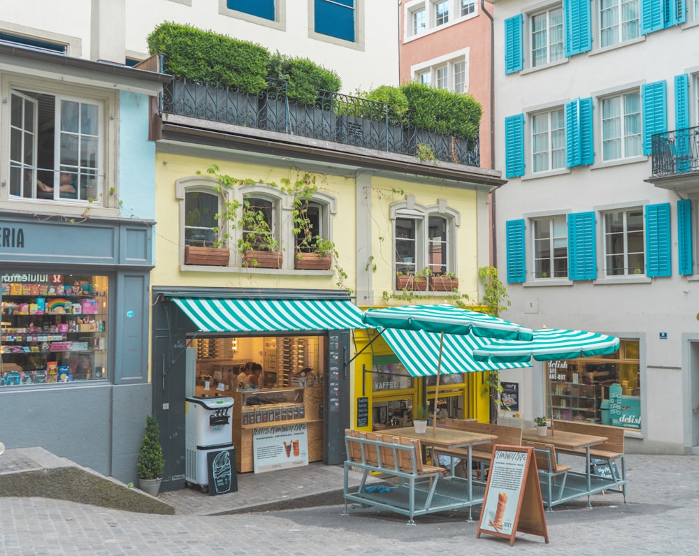 a street corner with tables and umbrellas in front of buildings