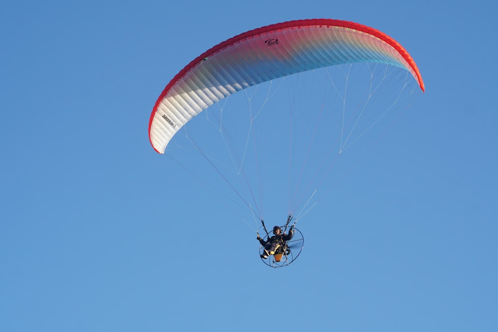 a person is parasailing in the blue sky