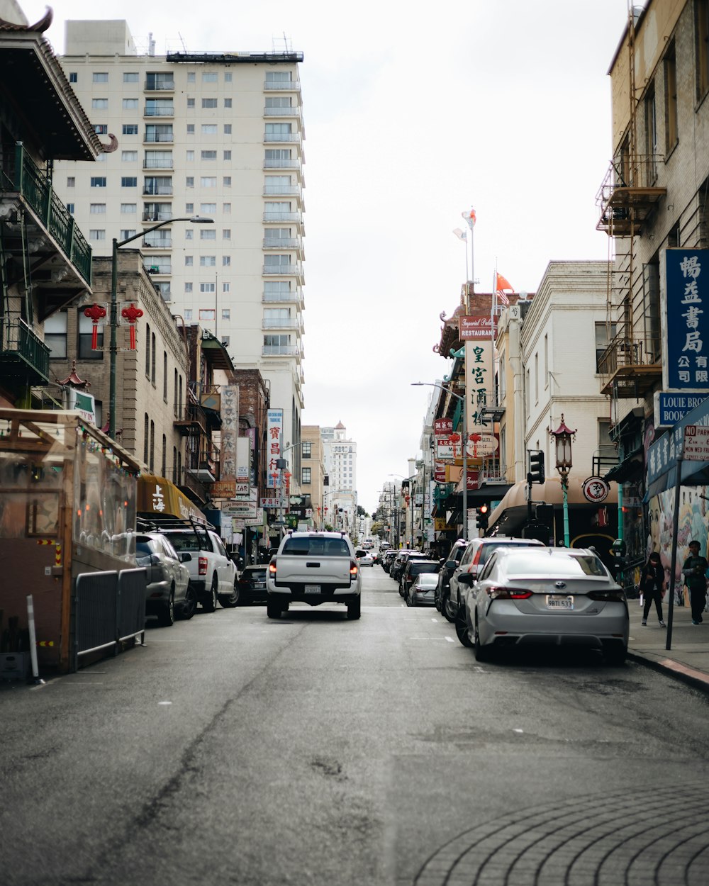 a city street filled with lots of traffic next to tall buildings