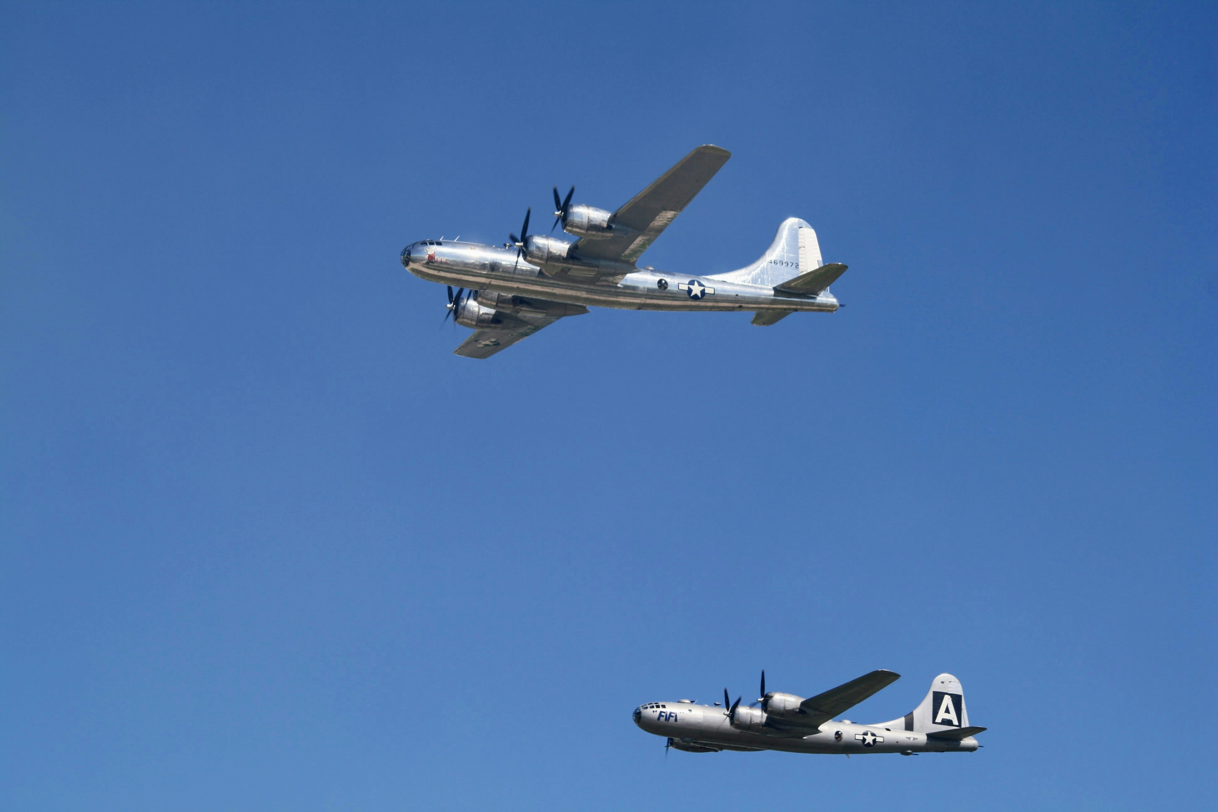 two planes flying in the air with a blue sky behind them, Two of the last airworthy B-29 Superfortress