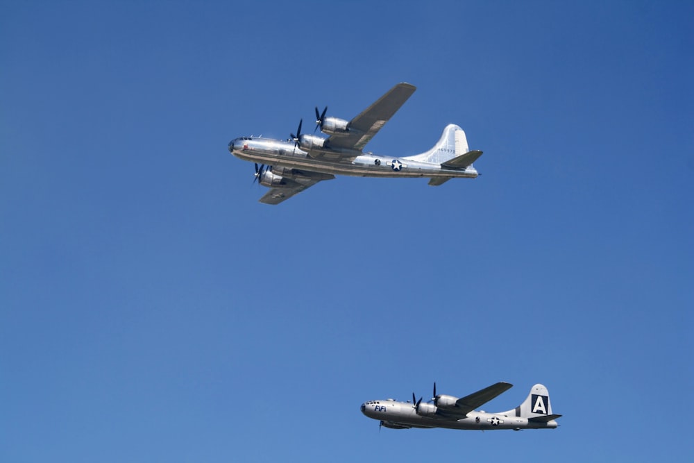 two planes flying in the air with a blue sky behind them