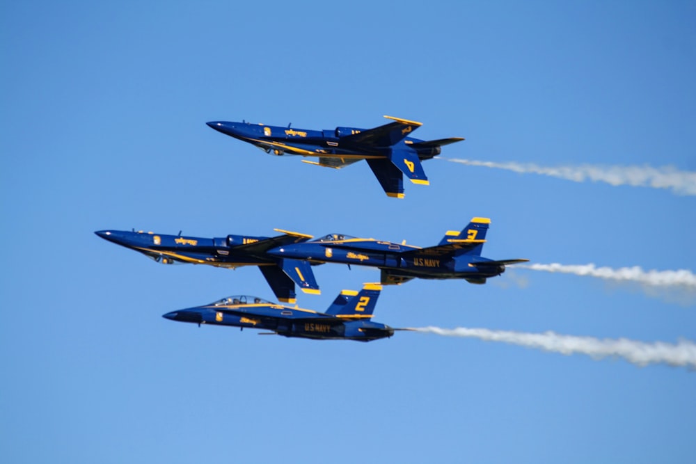 a group of fighter jets flying through a blue sky