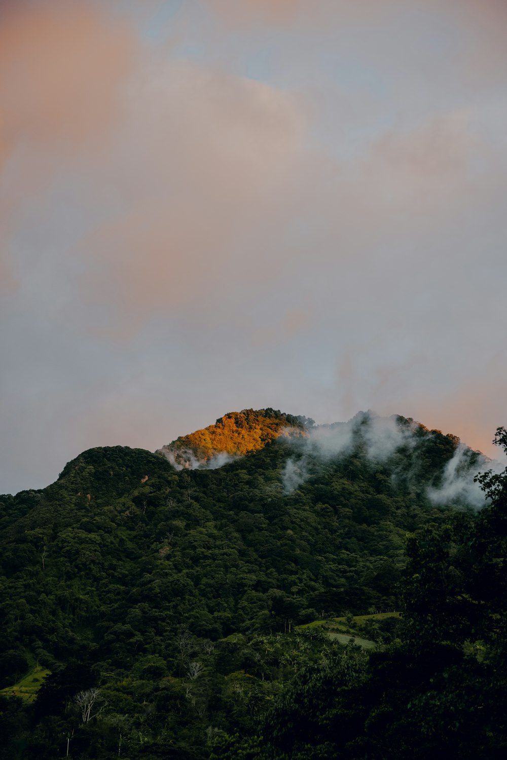 the top of a mountain covered in clouds