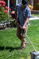 a man using a lawn mower to cut grass