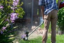 a man using a lawn mower to cut grass