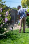a man using a lawn mower to cut grass