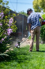 a man using a lawn mower to cut grass