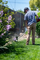 a man using a lawn mower to cut grass