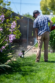 a man using a lawn mower to cut grass
