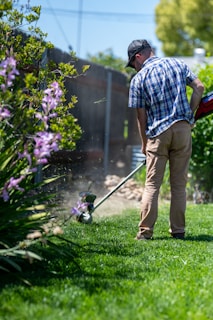 a man using a lawn mower to cut grass