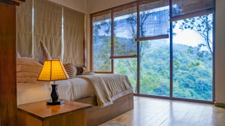 a bedroom with a large window and a bed