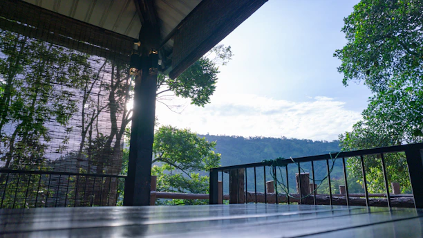 A serene yoga retreat setting with mats laid out on a wooden deck overlooking a peaceful forest.