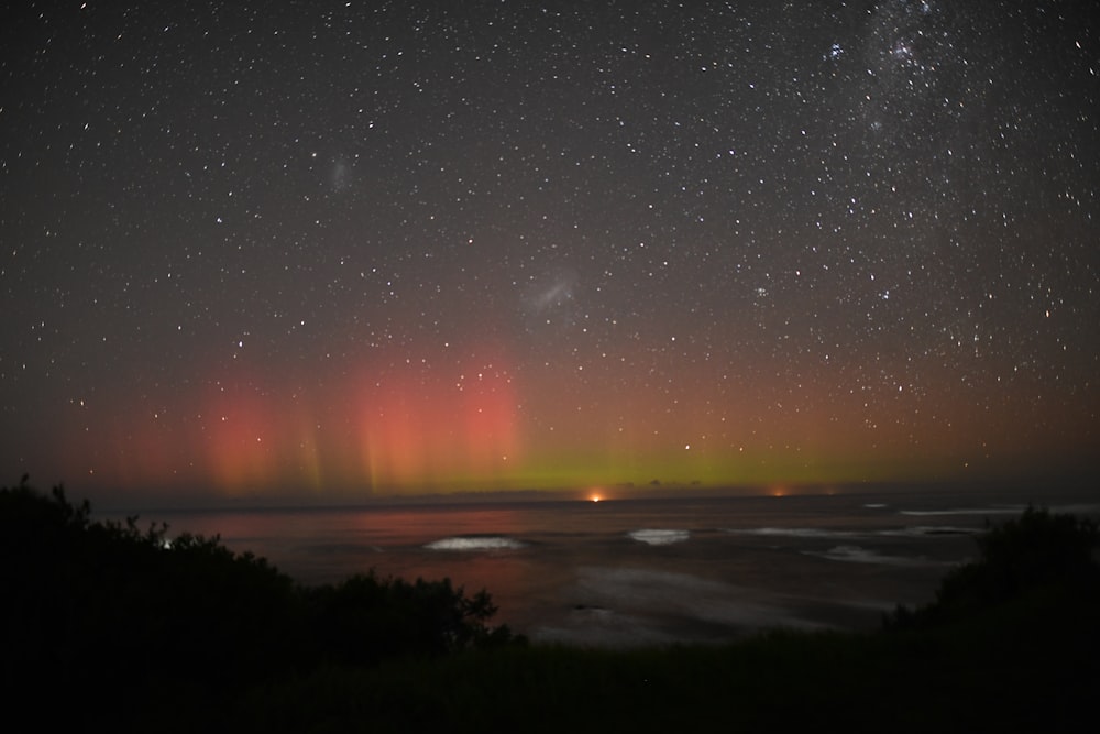 an aurora bore is seen in the sky over the ocean