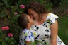 a woman kissing a boy in a field of flowers