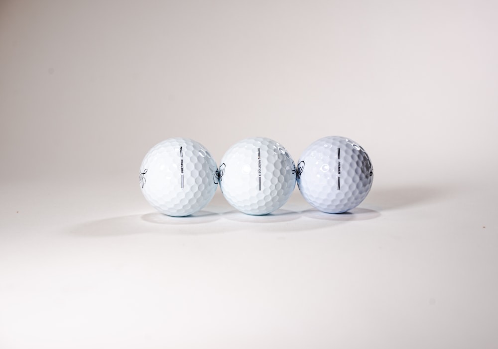 three white golf balls lined up in a row