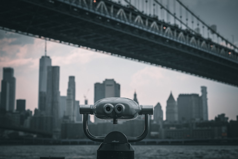 a close up of a camera with a bridge in the background