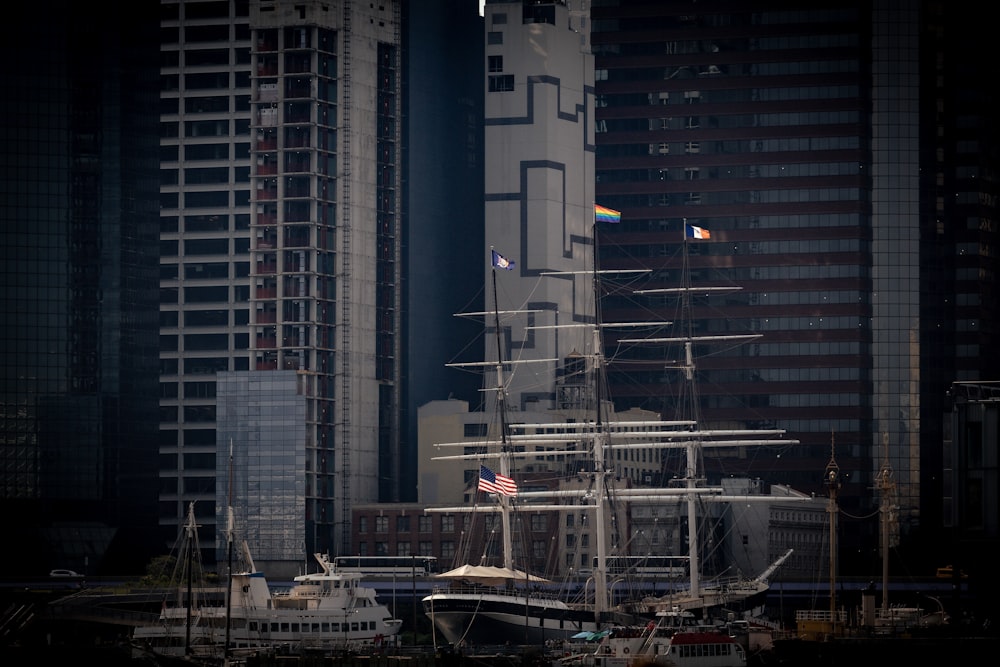 a large white boat floating in a harbor next to tall buildings