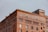 A large, historic brick building with 'The Eagle Warehouse & Storage Company' written prominently in white letters across the top. The structure features arched windows and decorative brickwork, adding to its architectural interest. A smaller section on top looks to be more modern, with larger windows overlooking the view.