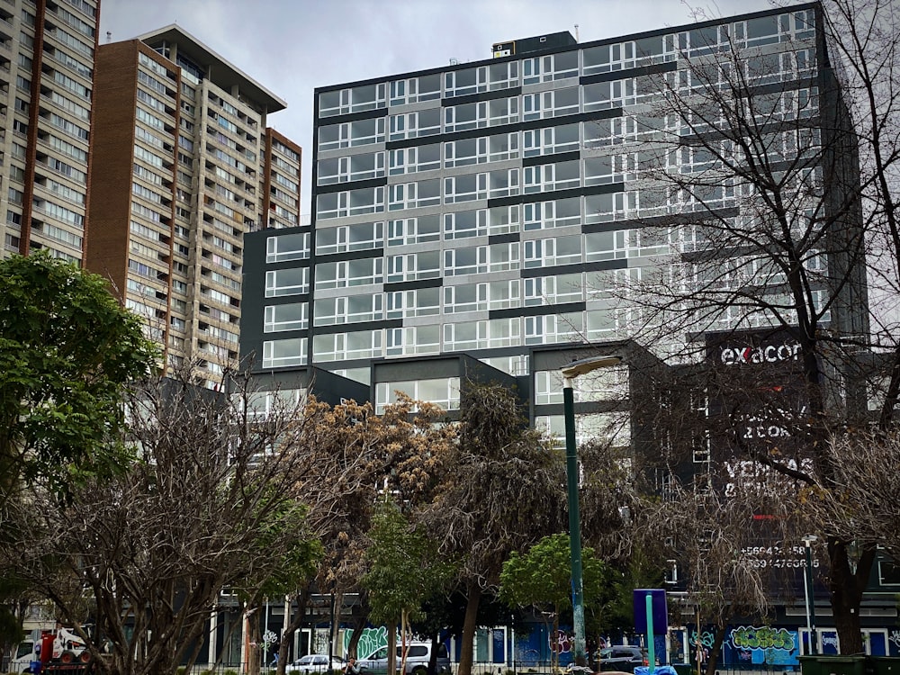 a tall building sitting next to a lush green park