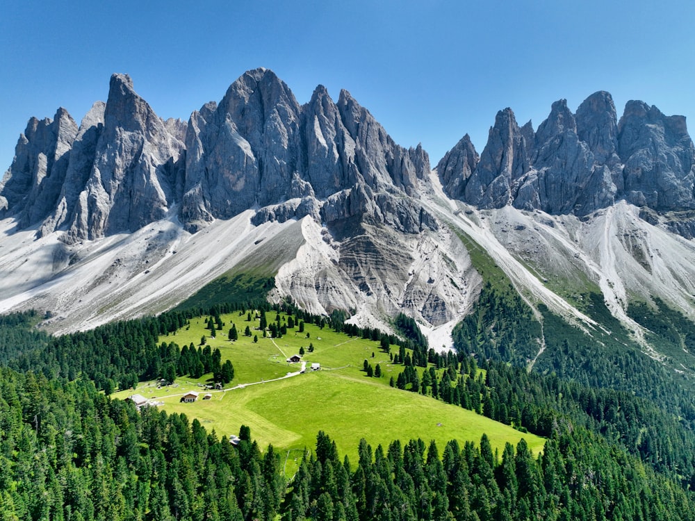 a green field in front of a mountain range