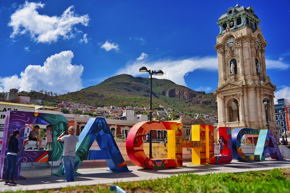 a man standing next to a large colorful sign