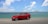 A scenic view of an SUV parked on a coastal road with mountains in the background.