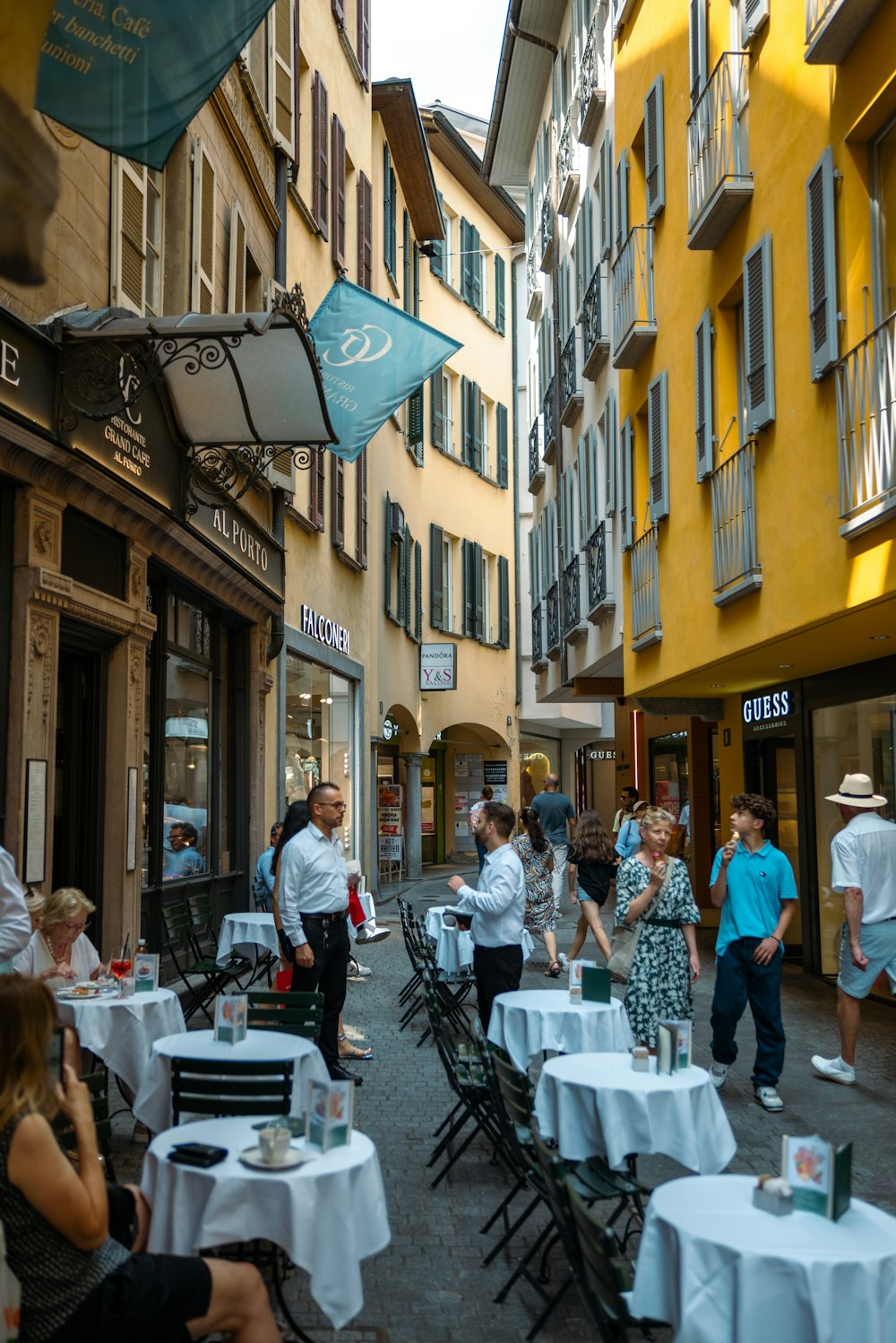 a group of people walking down a street next to tall buildings