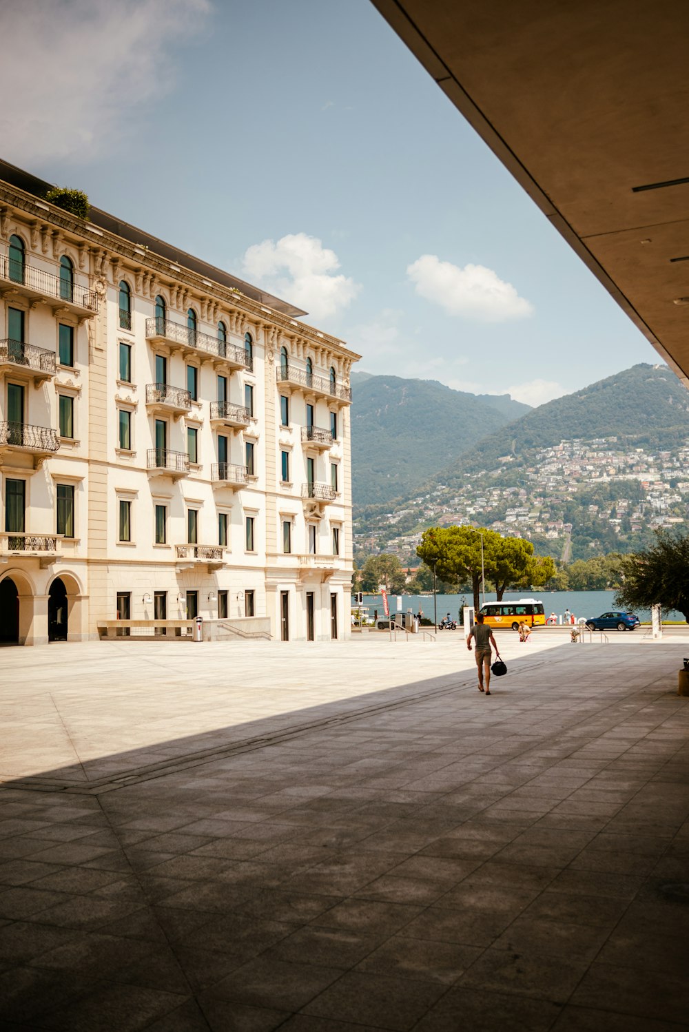 a person walking down a sidewalk in front of a large building