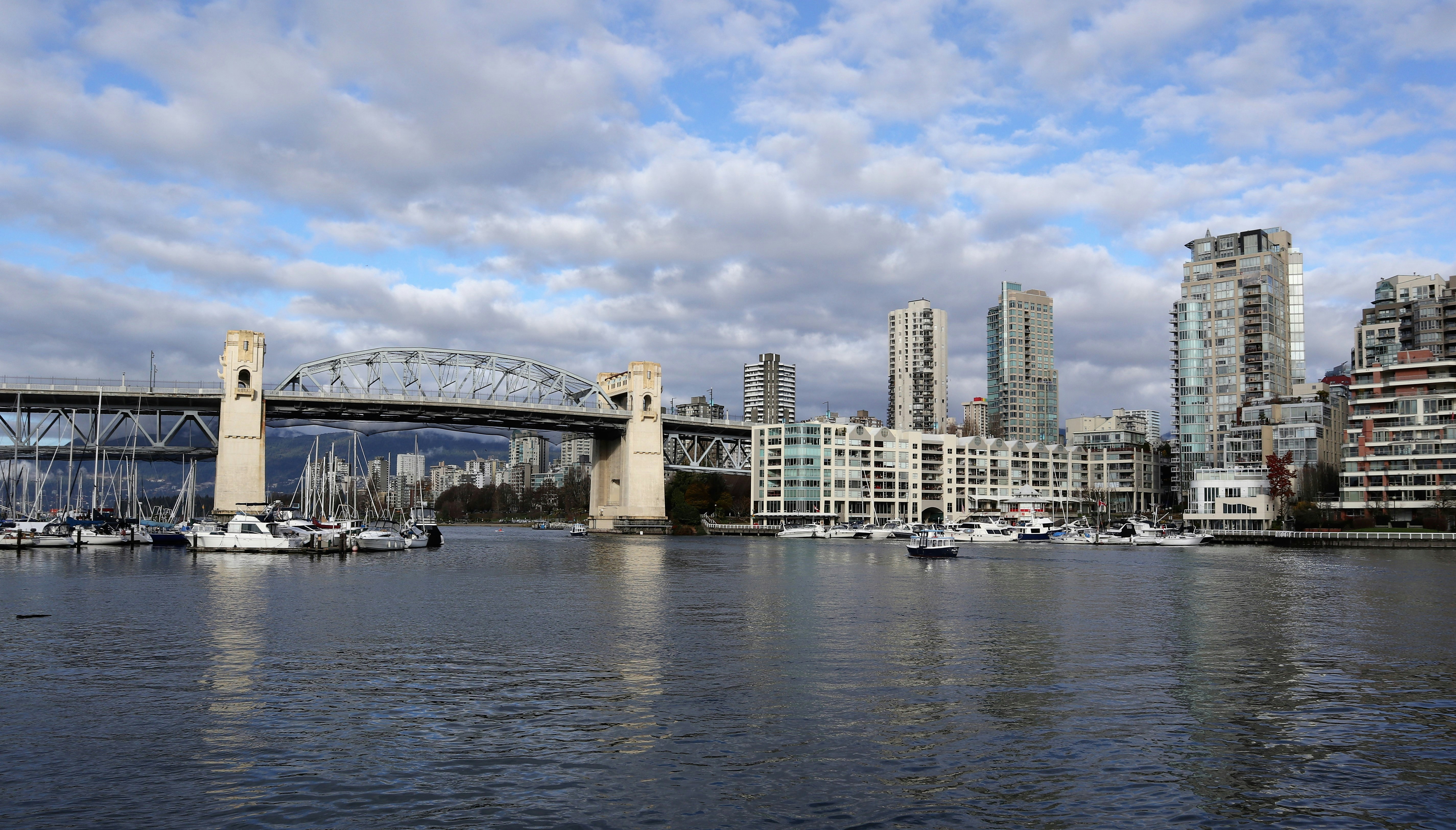 a bridge over a body of water with a city in the background