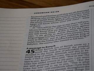 A close-up view of an open Bible page, showing text from the book of Jeremiah. The text appears in a column format with chapter and verse numbers visible. The page has a slightly blurred focus, with emphasis on specific verses of a religious text.