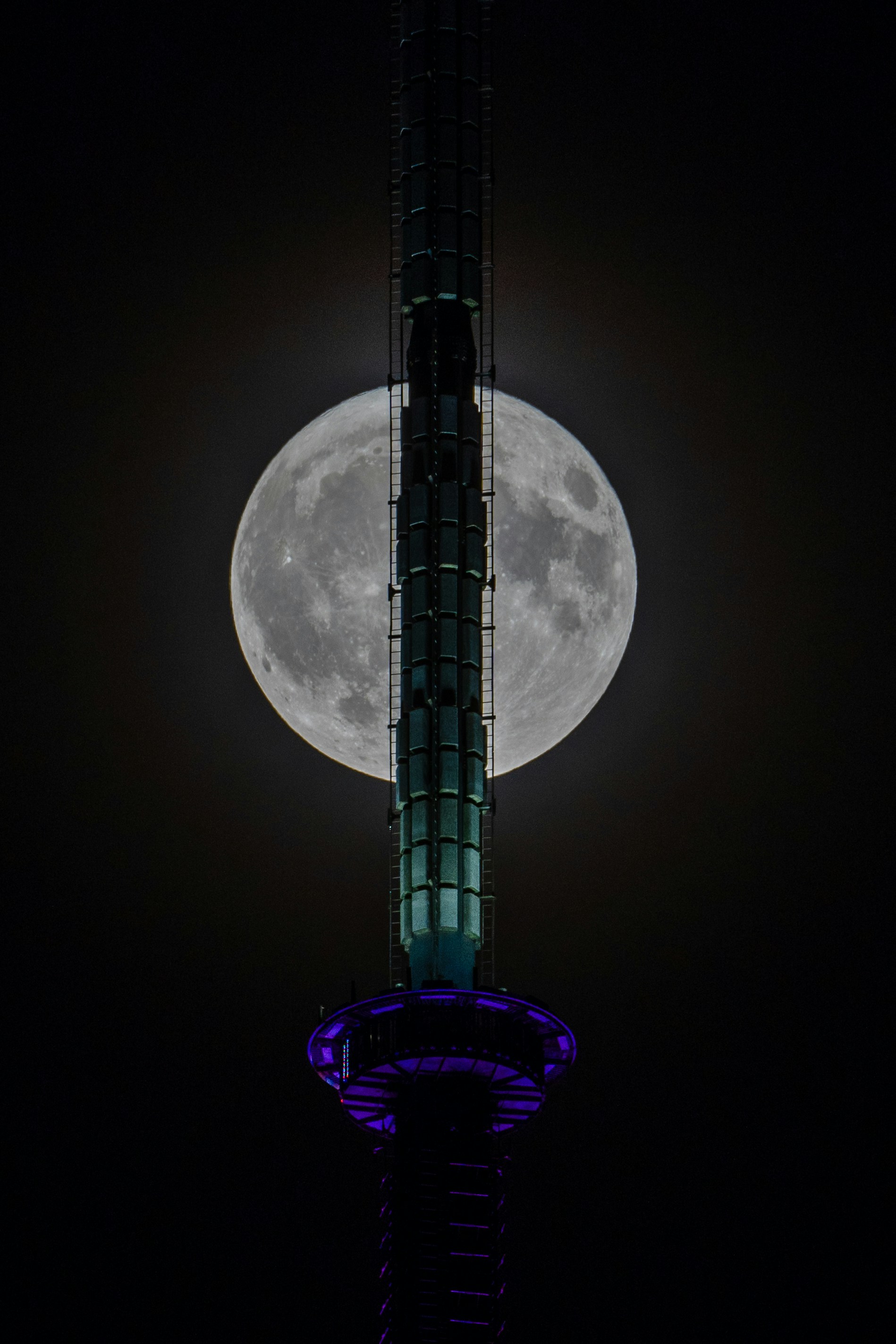 A tall tower with a very large moon in the background photo – Free Moon ...