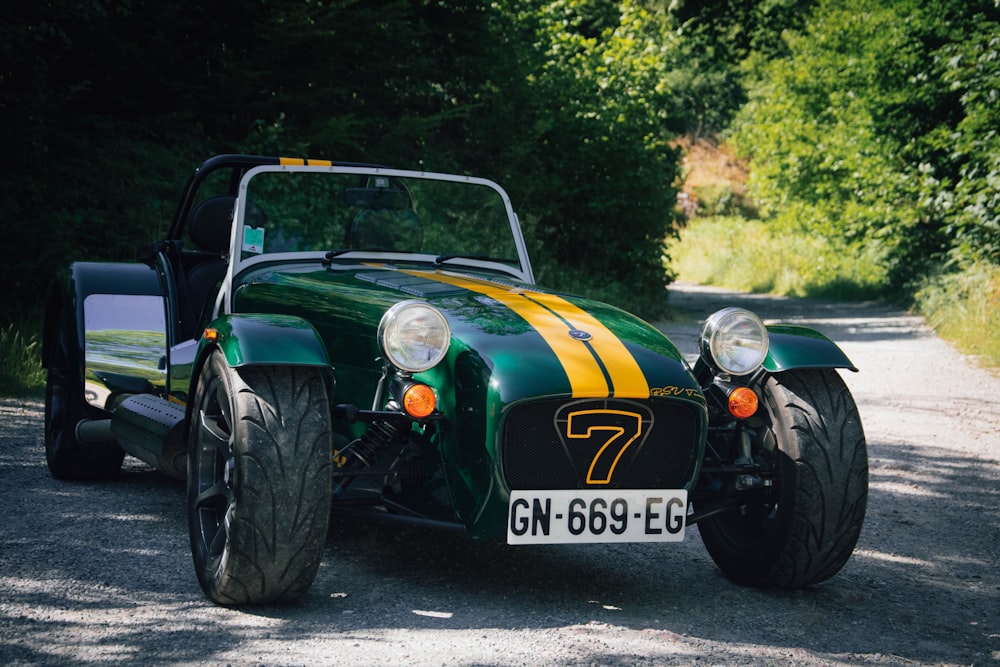 a green and yellow car parked on a gravel road