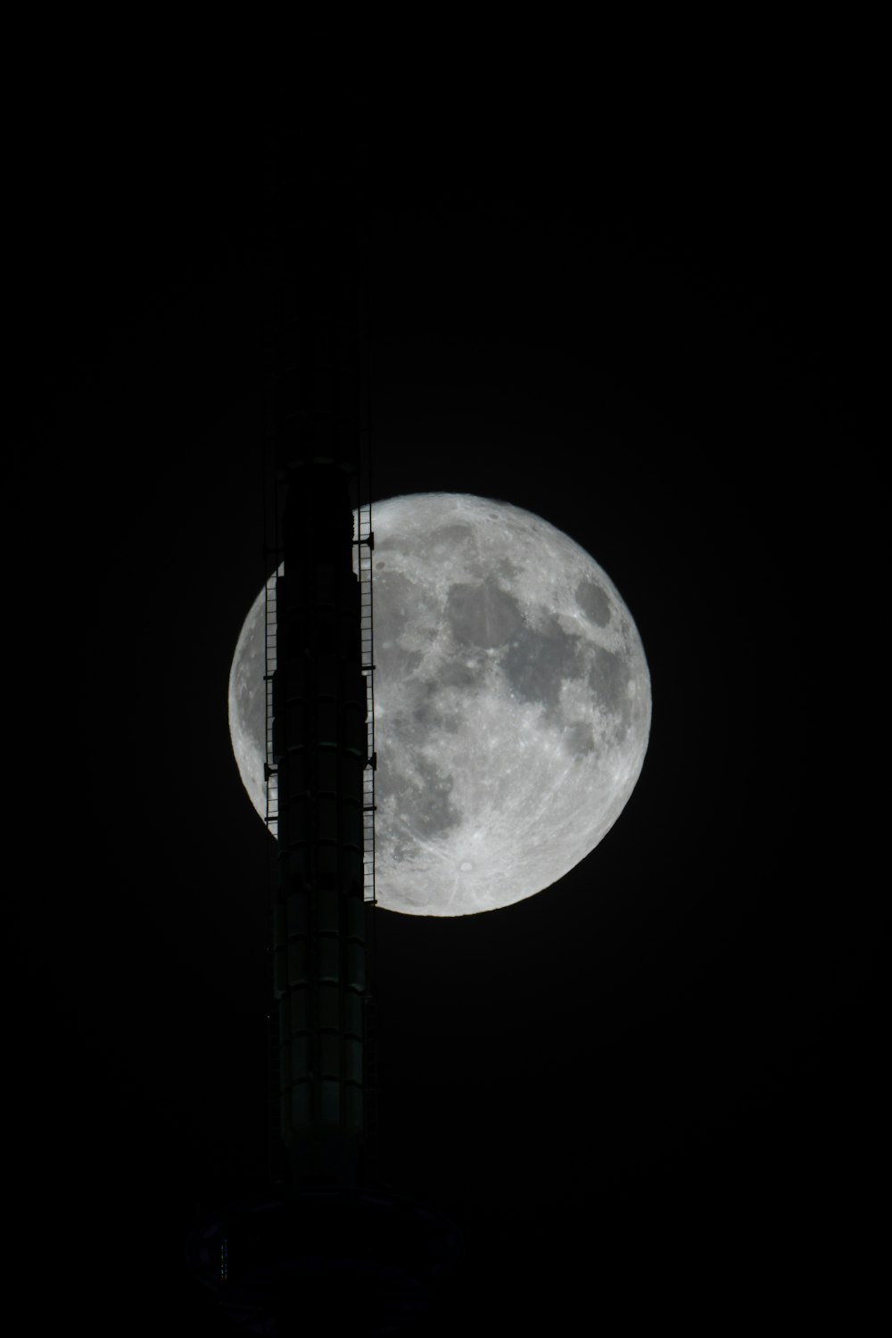 a very tall tower with a big moon in the background