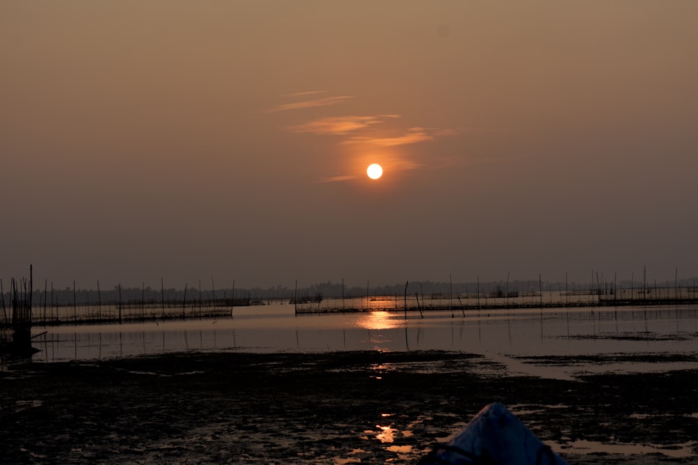 the sun is setting over a body of water