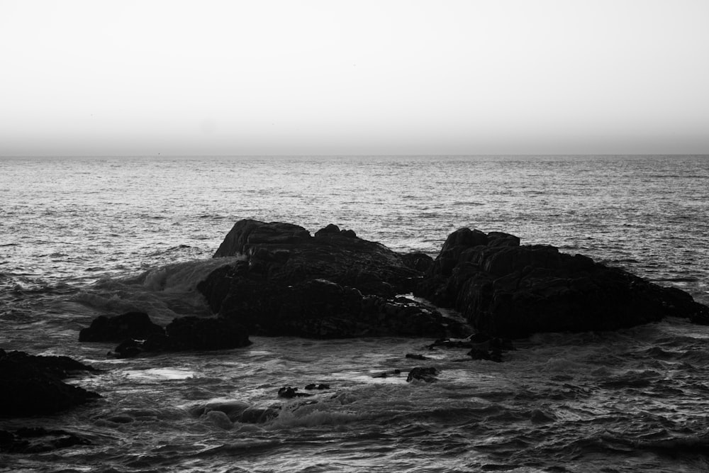 a black and white photo of some rocks in the water