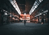 a person standing in a large building with lots of windows