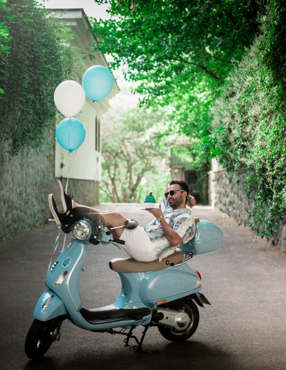 a man is sitting on a scooter with balloons