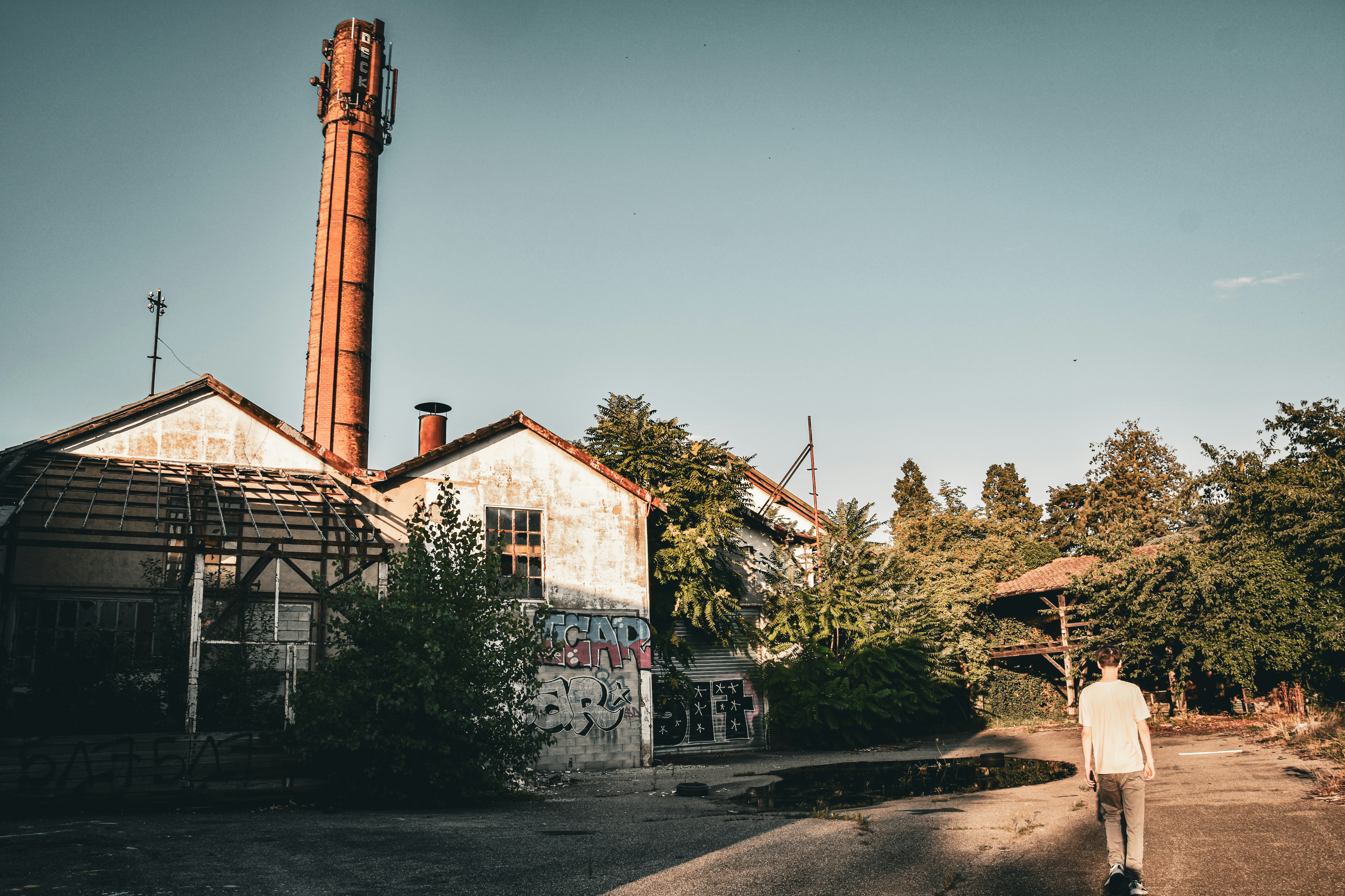 a man walking down a street next to a building