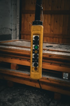 Close-up of an industrial control cabinet with illuminated switches and wiring inside a factory setting.