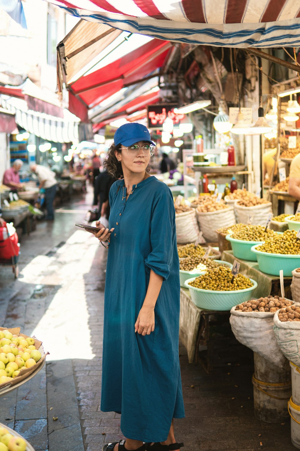 a woman standing in front of a fruit stand