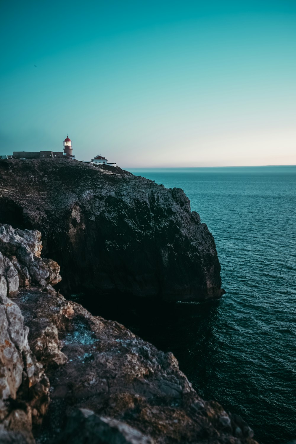 a lighthouse on a cliff overlooking the ocean