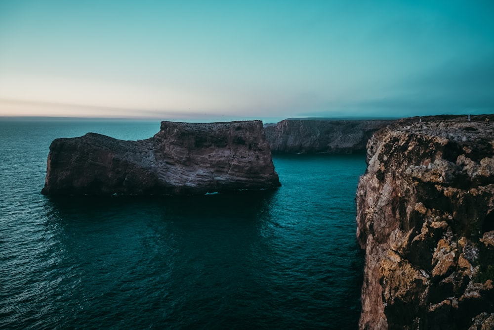 a large rock formation in the middle of a body of water