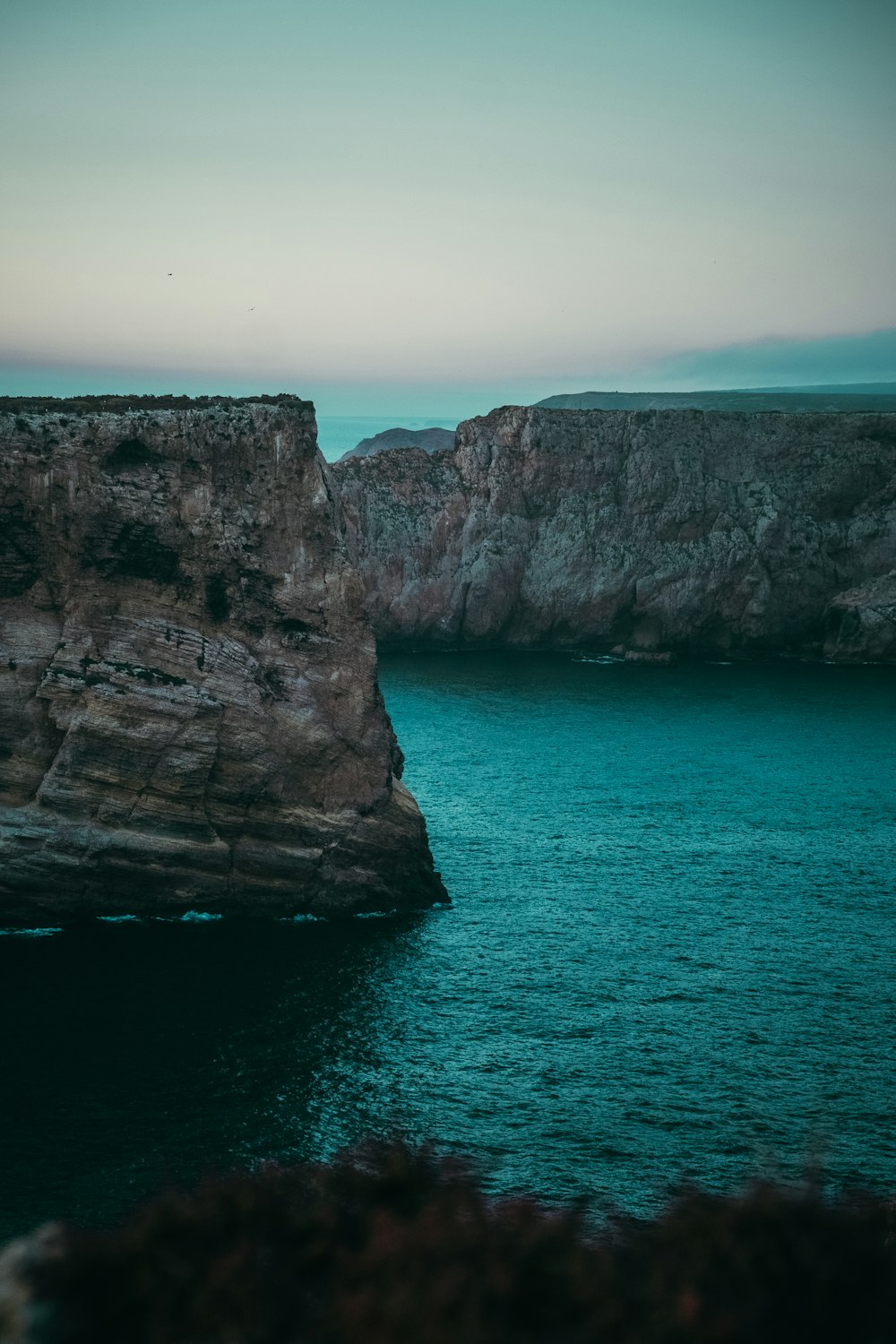 a large body of water near a rocky cliff