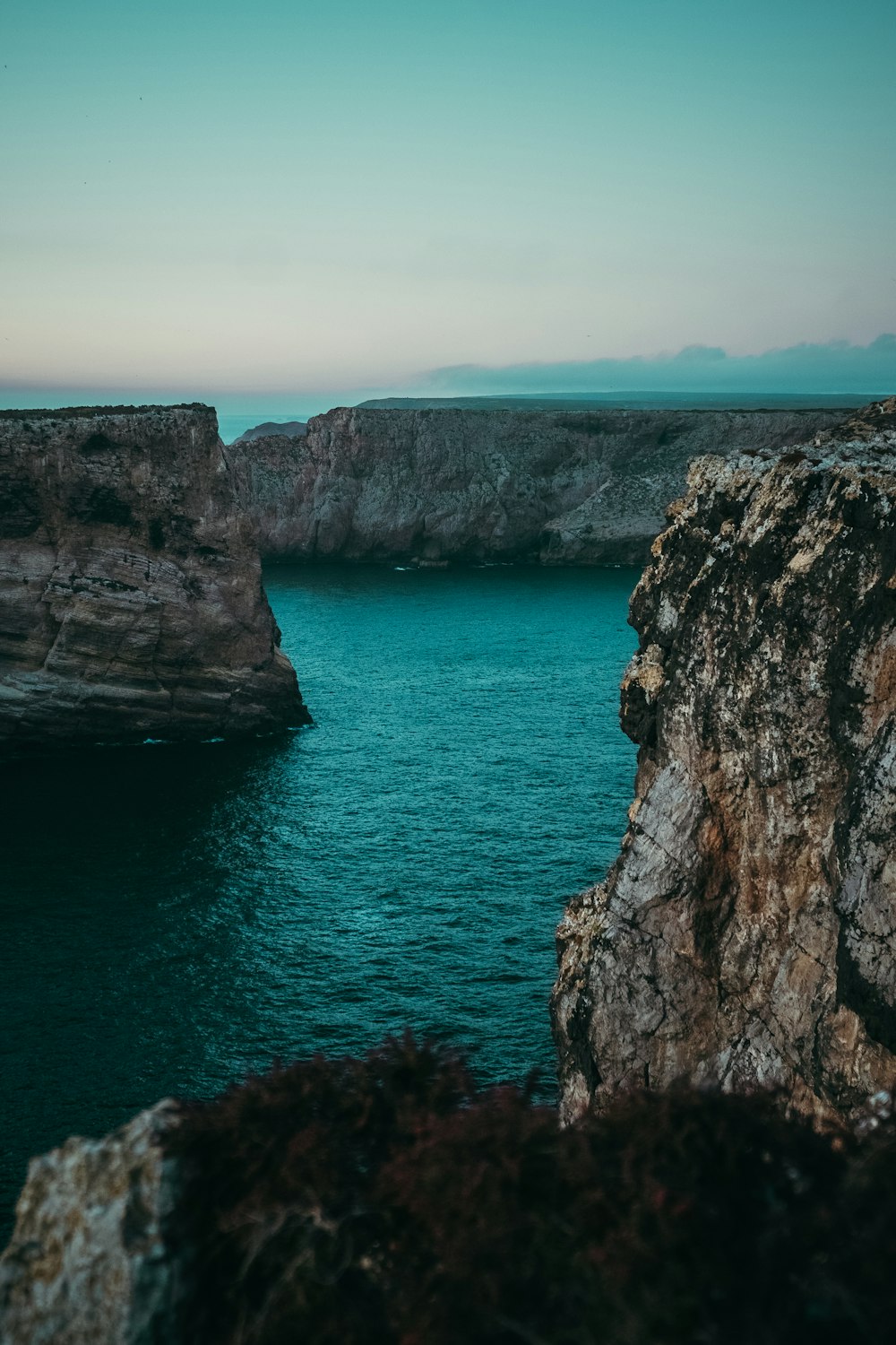 a large body of water near a rocky cliff