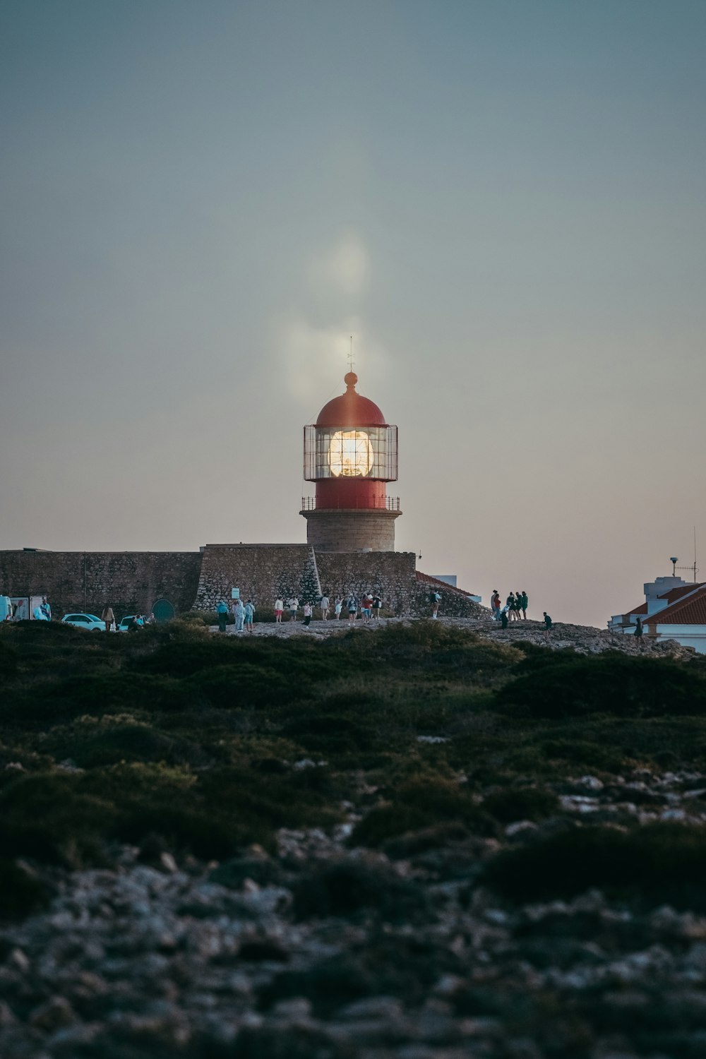 a red and white light house sitting on top of a hill
