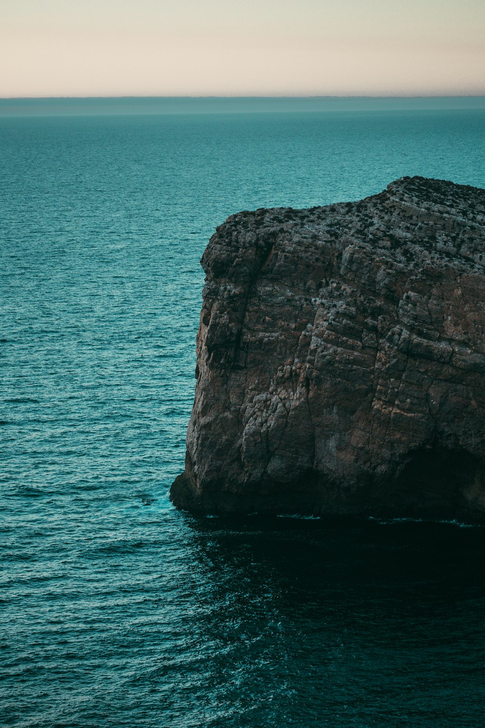 a large rock sticking out of the ocean