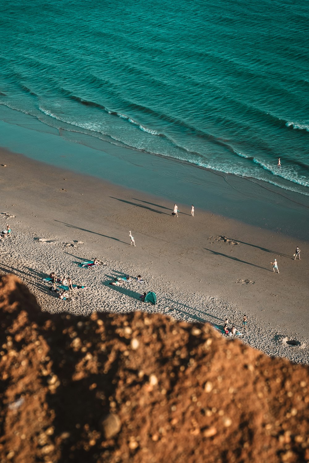 um grupo de pessoas em pé em cima de uma praia de areia